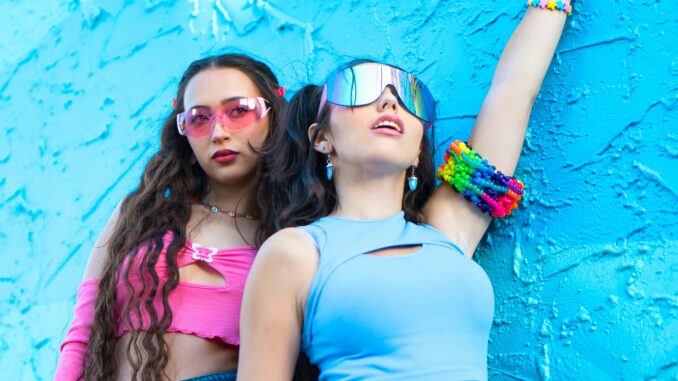 pexels-ak-photography-media-434382811-16817066 Two females in crop tops leaning on a blue wall